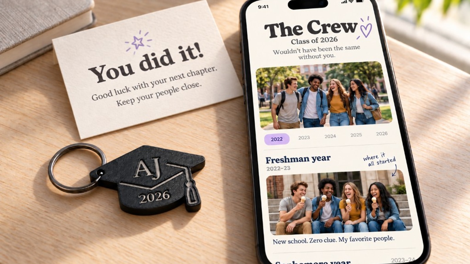 Graduation cap keychain beside a phone open to The Crew yearbook and a keepsake card